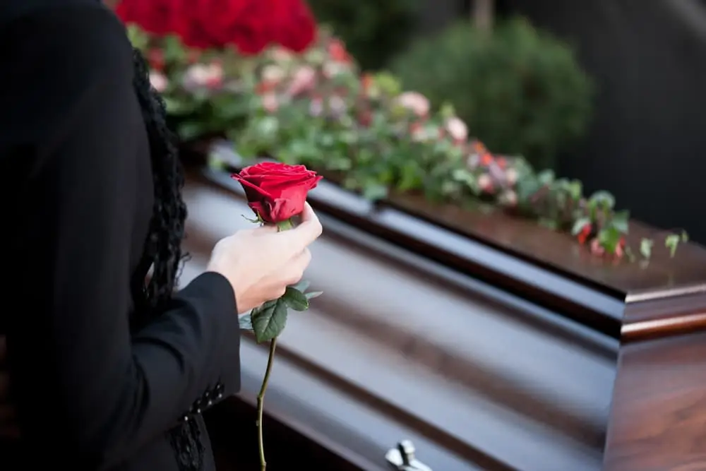 person holding a flower during a funeral