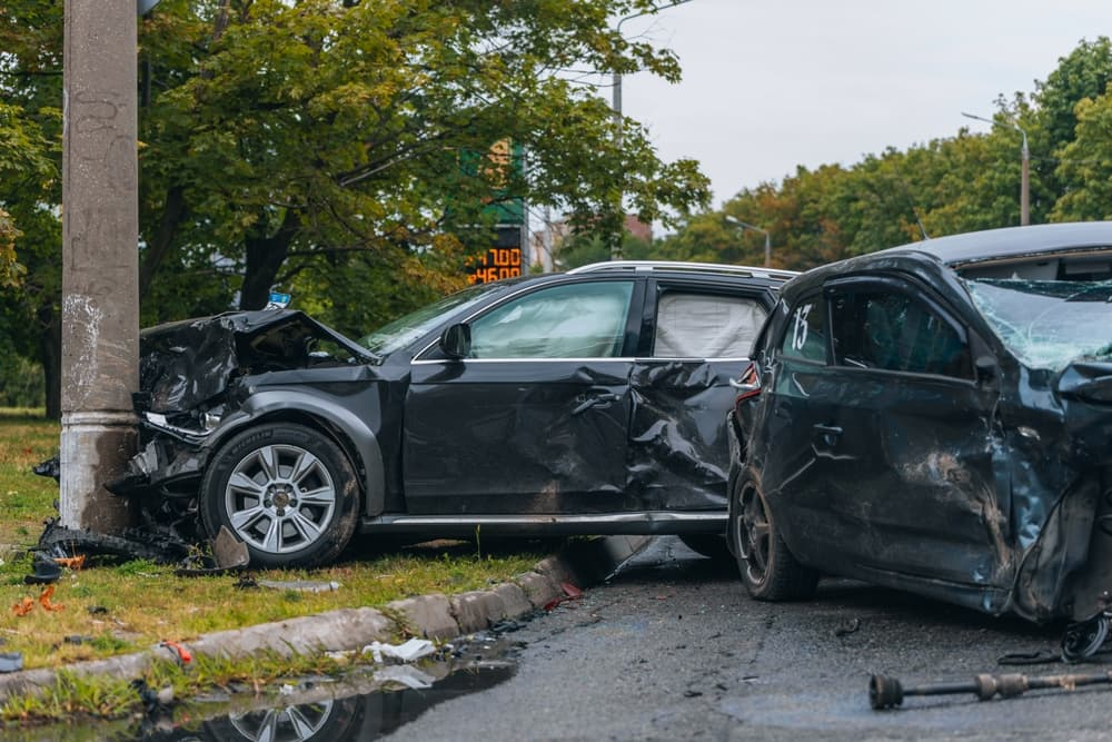 Close-up of a car's broken bumper and hood after a collision with a pole in Colorado Springs.