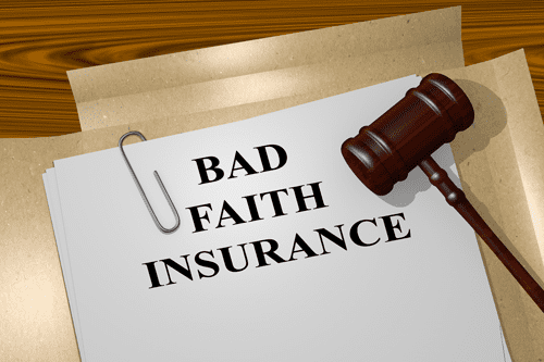 A stack of legal documents labeled “Bad Faith Insurance” secured with a paper clip rests on a wooden surface, with a judge’s gavel placed diagonally on top, symbolizing an insurance dispute or legal action against an insurer.