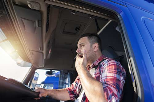 Tired truck driver yawning